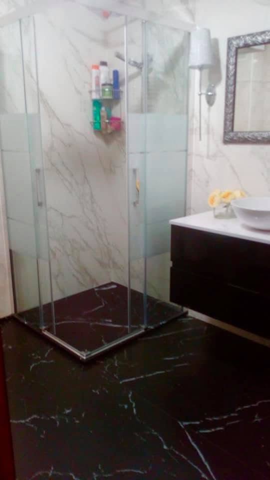 Baño de diseño revestido en Neolith Marquina y Estatuario