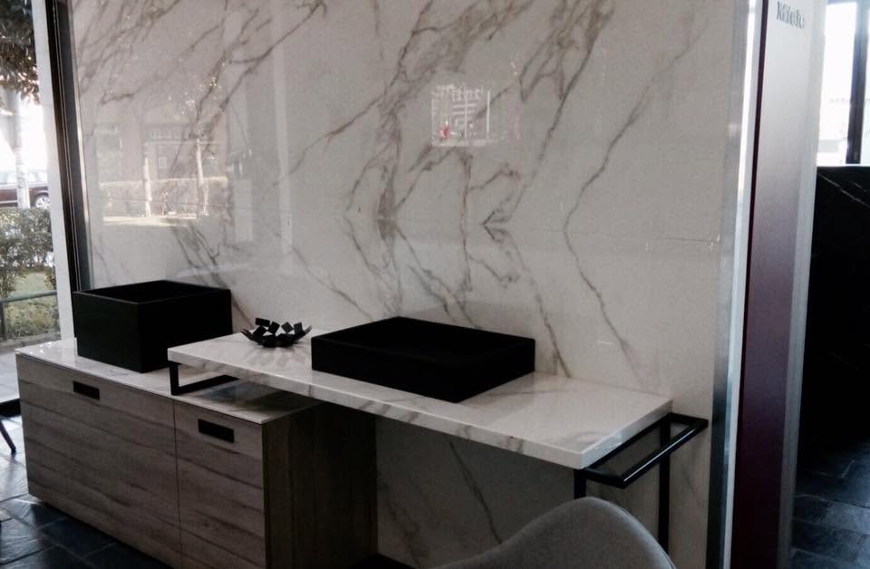 Baño de diseño con revestimiento efecto mármol y encimera a medida