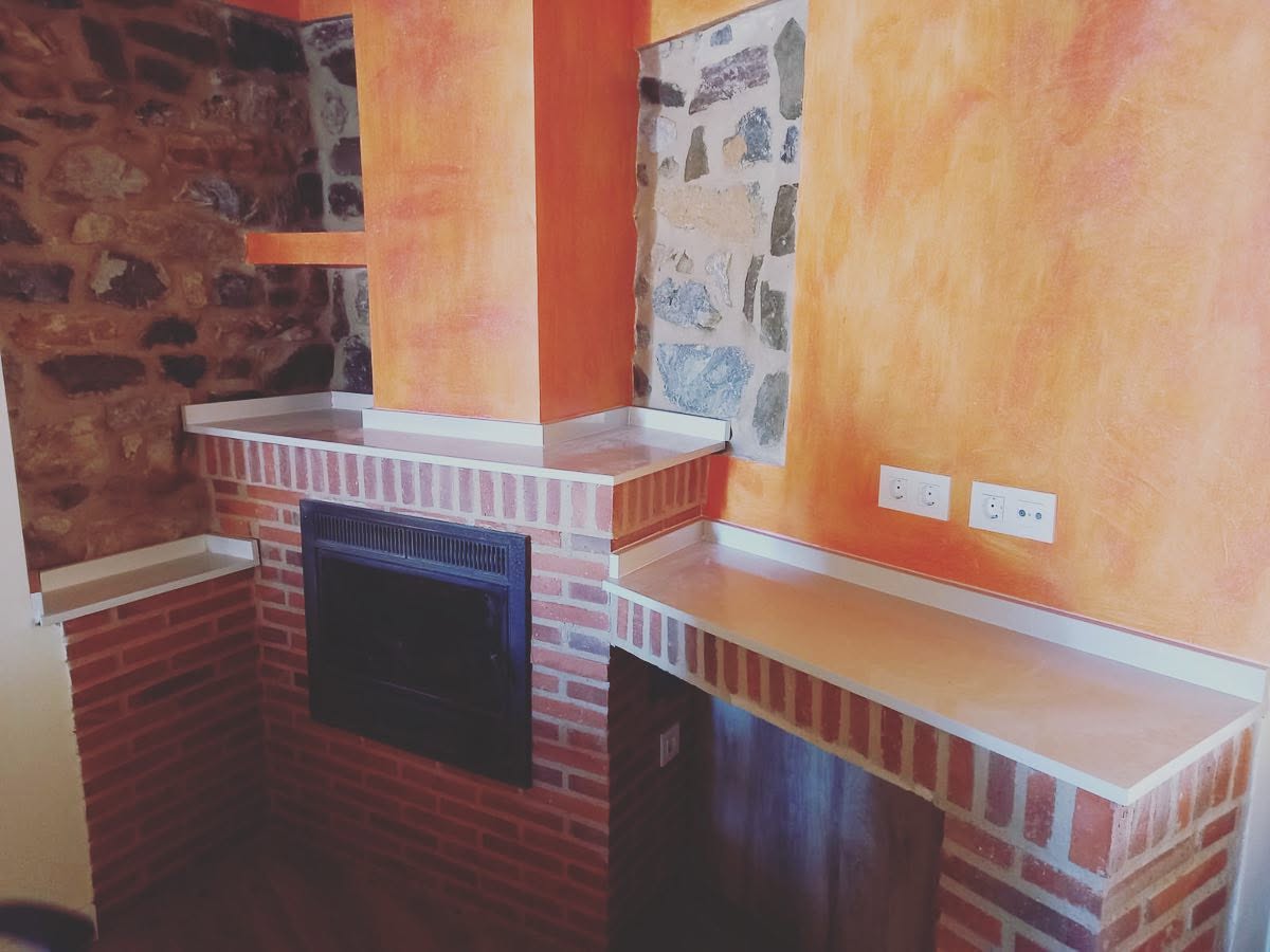 Chimenea y superficies en COMPAC Alaska para casa rústica en la montaña leonesa