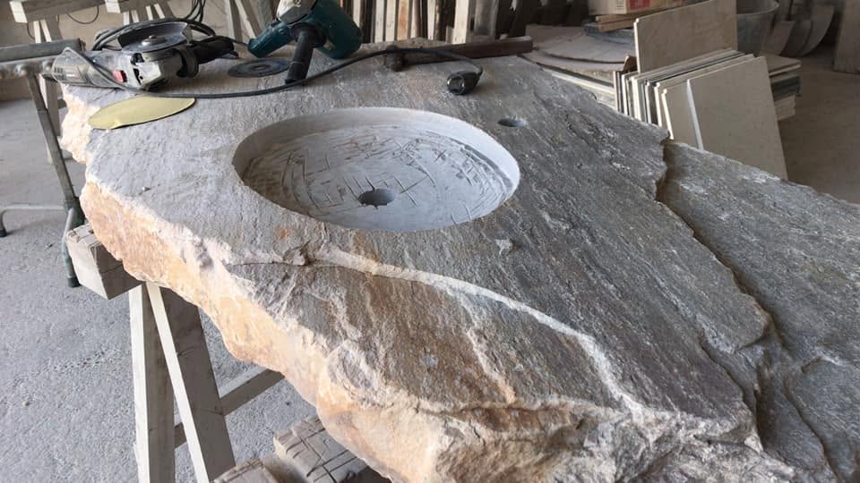 Encimera de baño artesanal con lavabo tallado en piedra natural