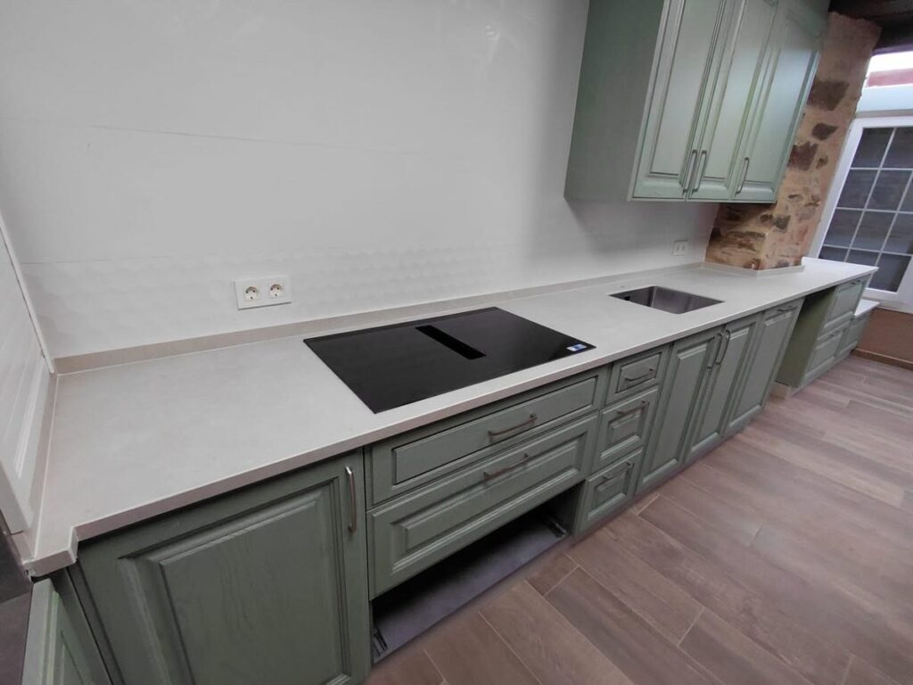 Encimera de cocina Laminam integrada con muro de piedra