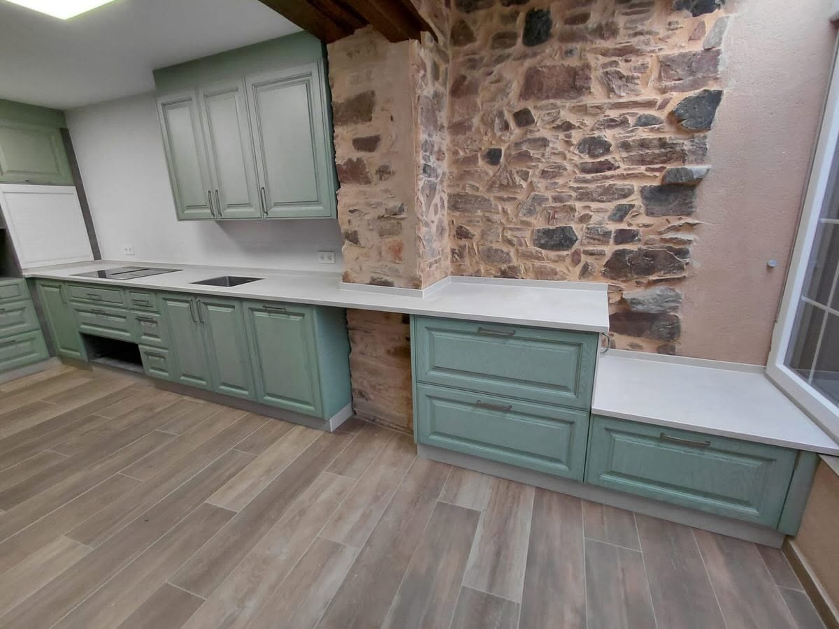 Encimera de cocina Laminam integrada con muro de piedra