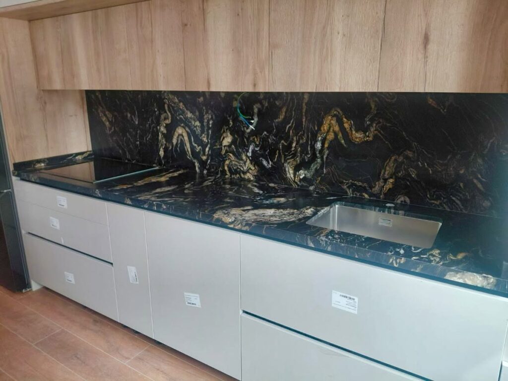 Encimera e isla de cocina en piedra natural con revestimiento a juego