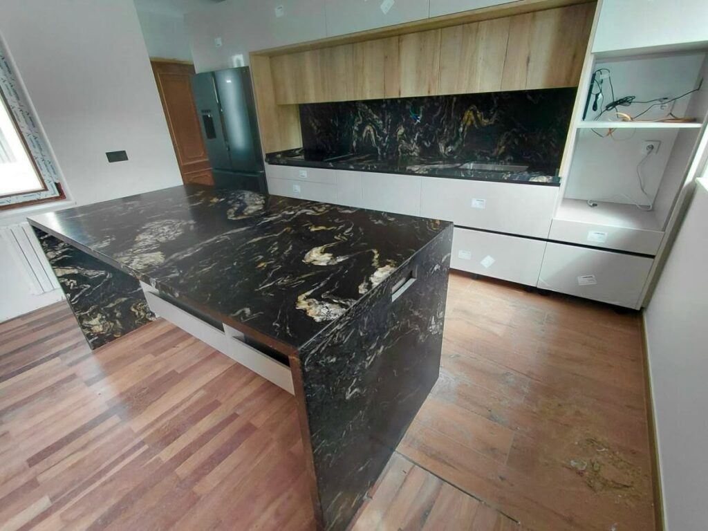 Encimera e isla de cocina en piedra natural con revestimiento a juego