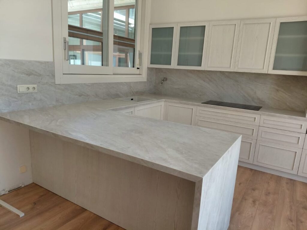 Encimera Laminam con península revestida y frontal de cocina