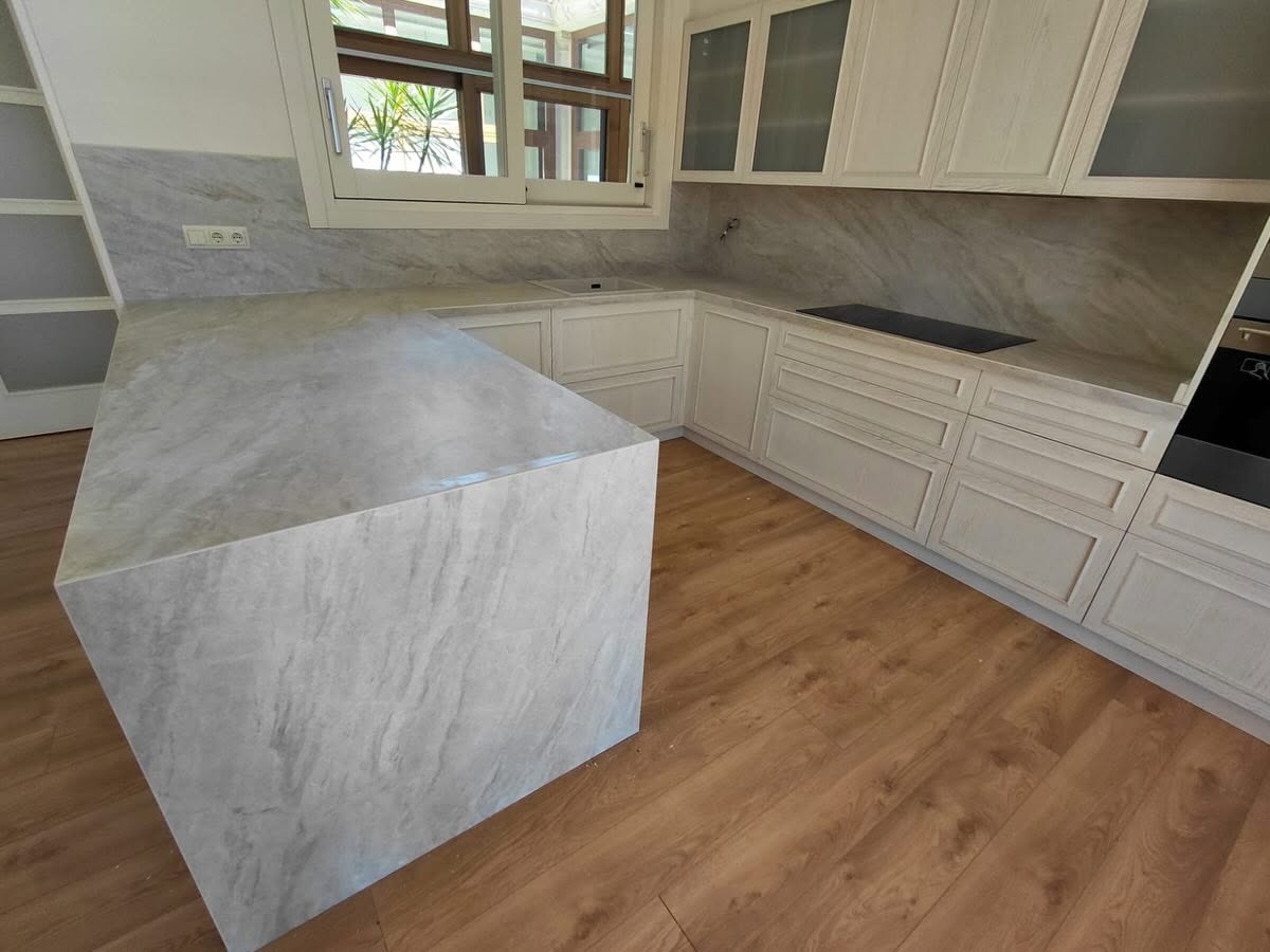Encimera Laminam con península revestida y frontal de cocina