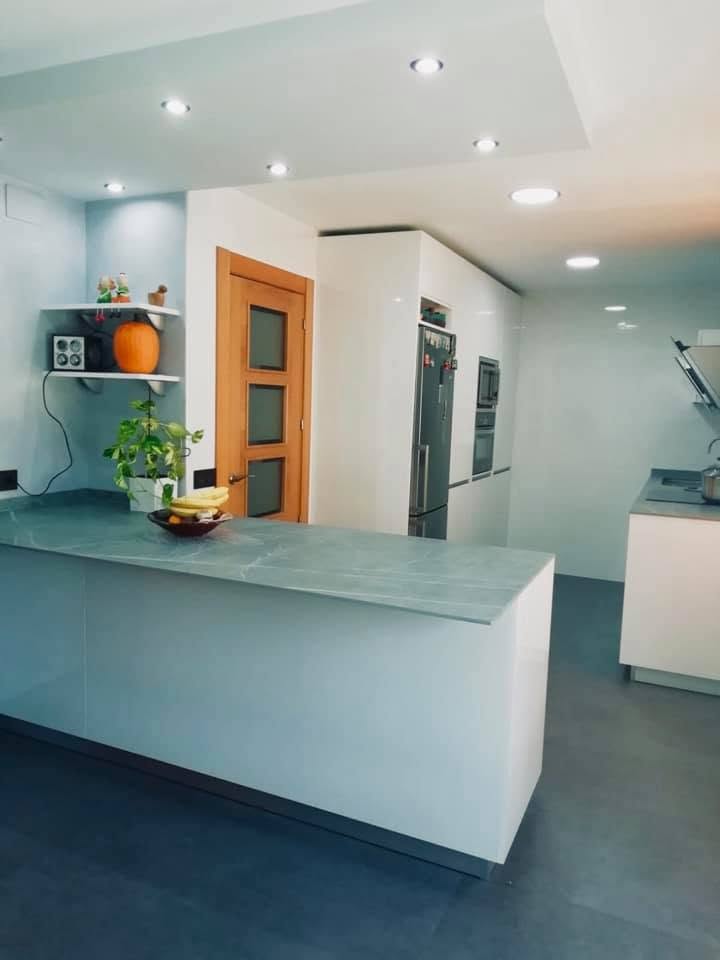 Encimera Neolith en cocina blanca con península