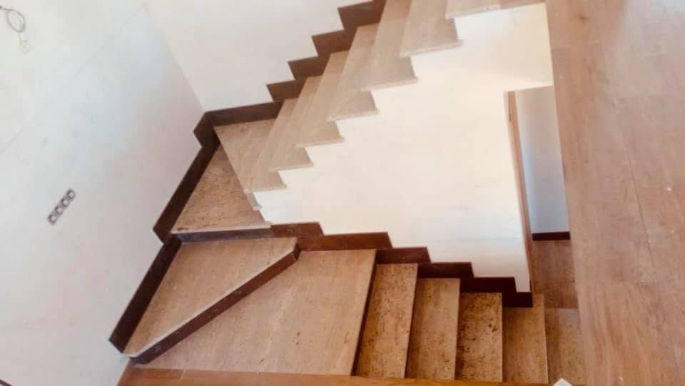 Escalera interior revestida en piedra natural con peldaños a medida