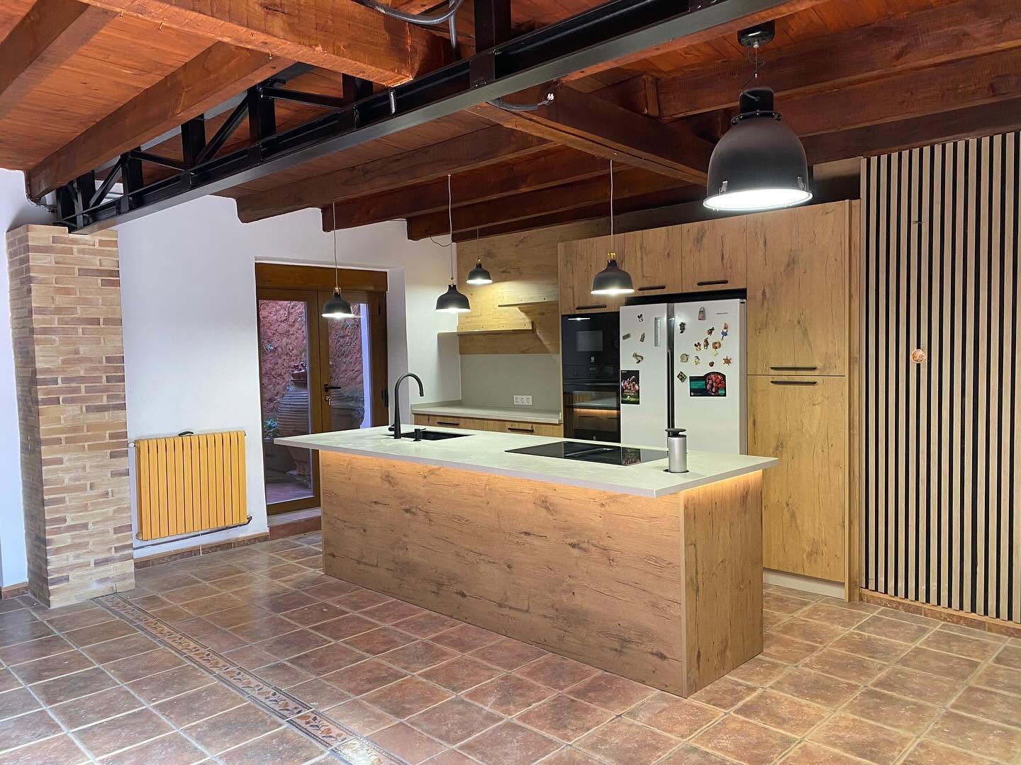 Isla de cocina con desayunador en Laminam para vivienda de diseño rústico moderno