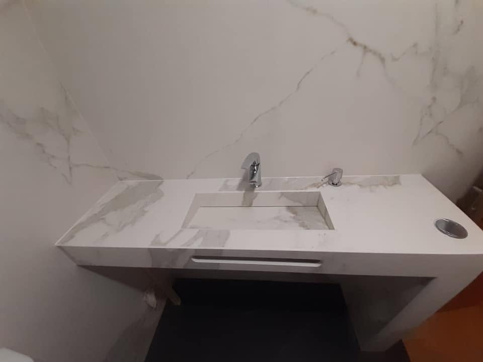 Lavabo integrado y revestimiento de baño en Neolith Statuario