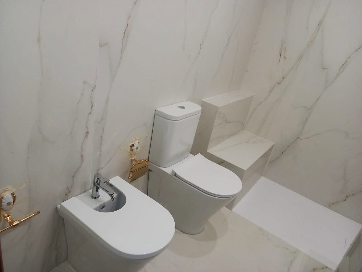 Revestimiento de baño porcelánico Laminam Oro del Jerte con banco integrado